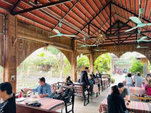 Xuân Sơnhappy bungalow homestay的一群人坐在餐厅的桌子旁