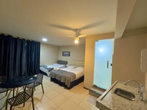a hotel room with two beds and a bathroom at VA Apart Hotel Savassi in Divinópolis