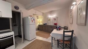 Casa Del Saint Paul في سان بول دي فينس: مطبخ مع طاولة وثلاجة بيضاء +22 صورة