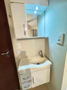 a bathroom with a sink and a mirror at VA Apart Hotel Savassi in Divinópolis +99 photos