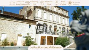 a large stone building with stairs in front of it at Pavillon des Millésimes, Piscine & SPA in Lussac