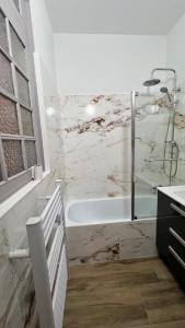 Un baño blanco con bañera y lavabo. en Appartement Les Halles , Climatisation, Terrasse, Garage, en Narbona