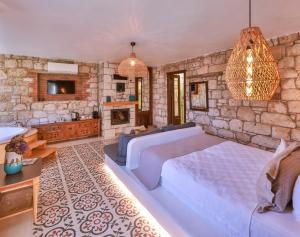 a bedroom with a large bed and a stone wall at Cumbali Konak Hotel (Adults Only +12) in Alaçatı
