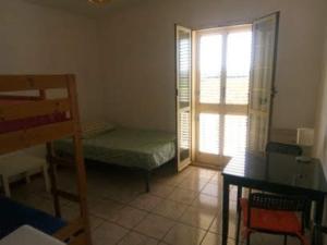 a room with a bed and a table and a window at Camera doppia in affitto con bagno privato Interno in Marina di Montenero