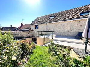 ein Haus mit einer Terrasse und einem Dach in der Unterkunft Calme et détente avec jacuzzi, jardin et terrasse in Trigny