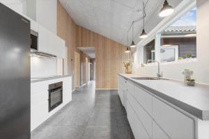 菲耶勒鲁普8876-Glesborg-Strandvejen-43的带白色橱柜和水槽的厨房