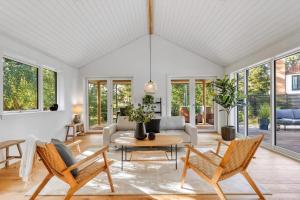 a living room with a couch and chairs and a table at Arkitekttegnet Sommerhus Tæt På Vandet in Marielyst