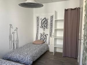 une chambre avec un lit orné de dessins de girafes sur les murs dans l'établissement APPART'AGEN, à Agen 41 autres photos