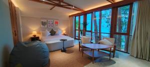 a bedroom with a bed and a table and chairs at Pebble Lanta - Seaview Stay in Ko Lanta