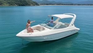 Dos mujeres están de pie en un barco en el agua en Flamboyant Boat, en Ubatuba