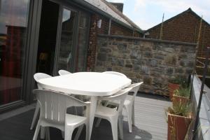 un tavolo bianco e 2 sedie bianche su un balcone di Les Secrets du Chat a Clavier
