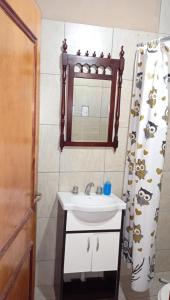 La salle de bains est pourvue d'un lavabo, d'un miroir et d'un rideau de douche. dans l'établissement El gringo, à Victoria