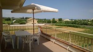 a balcony with a table and chairs and an umbrella at Camera doppia in affitto con bagno privato Interno in Marina di Montenero