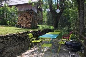 un tavolo con sedie e un grill in un cortile di Charmante maison familiale a Saint-Pierre-de-Chartreuse