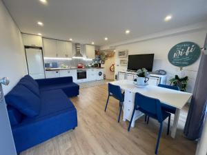 a living room with a blue couch and a table at Casinha do Lago in Ferreira do Zêzere