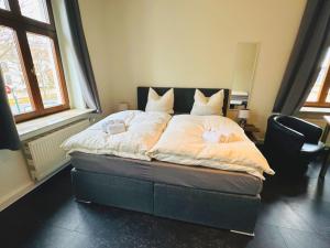 un dormitorio con una cama con sábanas y almohadas blancas en Hotel an der Rennbahn, en Dresden 2 fotos más