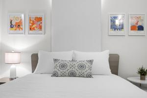 圣胡安Porta Linda Modern House Near The Airport的白色的卧室配有带枕头的白色床