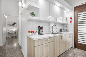 圣胡安Porta Linda Modern House Near The Airport的带白色橱柜和水槽的厨房