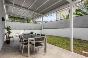 圣胡安Porta Linda Modern House Near The Airport的凉亭下有桌椅的露台