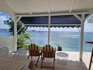a patio with a table and chairs and the ocean at Maison confortable à Saint Louis, 120 m², vue mer in Îlet à Christophe +7 photos