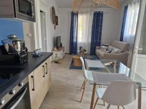 a kitchen and living room with a table and chairs at Maison confortable à Saint Louis, 120 m², vue mer in Îlet à Christophe