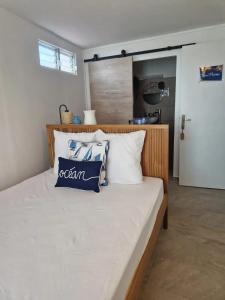 a bedroom with a large bed with white and blue pillows at Maison confortable à Saint Louis, 120 m², vue mer in Îlet à Christophe