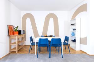 Un comedor con una mesa y sillas azules. en MOWO Marshall 8 - Apartmenthaus Kitzingen - großzügige Wohnungen für je 6 Personen mit Balkon, en Kitzingen