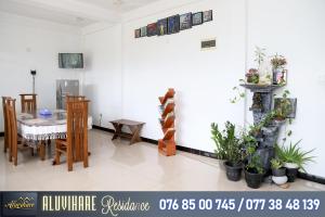 a dining room with a table and some plants at Aluvihare Residence in Matale
