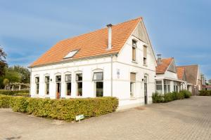 a white building with a red roof on a street at Mondri in Winterswijk
