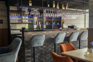 a bar with gray chairs and bottles of alcohol at Mondri in Winterswijk +8 photos