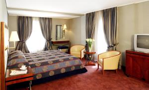 a hotel room with a bed and a tv at Piraeus Theoxenia Hotel in Piraeus +42 photos