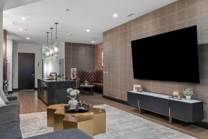 een woonkamer met een grote tv aan de muur bij French's Luxury Condo - Steps from Broadway in Nashville