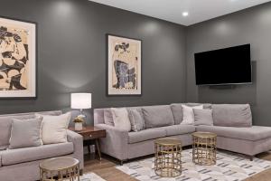 a living room with a couch and a flat screen tv at French's Luxury Condo - Steps from Broadway in Nashville