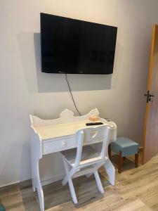 a white desk with a tv on a wall at Casa Penedo Vista da Serra in Itatiaia