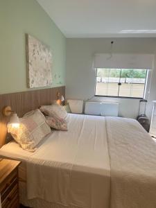 a large white bed in a room with a window at Casa Penedo Vista da Serra in Itatiaia +47 photos