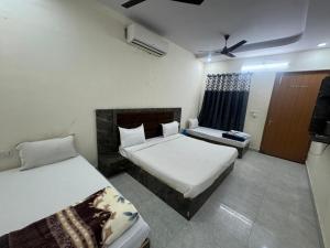 a hotel room with two beds and a window at Meera Residency Vrindavan in Vrindāvan +24 photos