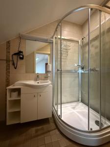 ein Badezimmer mit Dusche und Waschbecken in der Unterkunft Gargždų pramogos in Gargždai + 6 Fotos