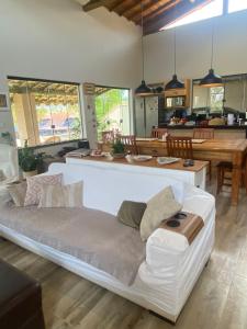 a large white bed in a room with a kitchen at Casa Penedo Vista da Serra in Itatiaia