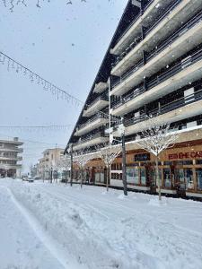 eine schneebedeckte Straße vor einem großen Gebäude in der Unterkunft magnifique appartement au centre de Montana in Crans-Montana