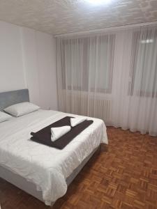 a bedroom with a bed with a black blanket on it at San centar apartment in Banja Luka