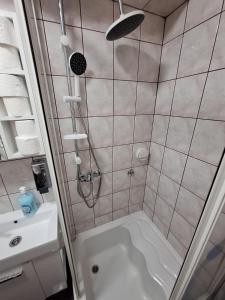 a bathroom with a shower with a tub and a sink at San centar apartment in Banja Luka +14 photos