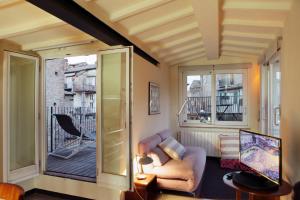 a living room with a couch and a balcony at LA COSTARELLA - Central with Cozy Terrace in Siena