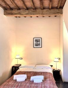 a bedroom with a large bed with two lamps at LA COSTARELLA - Central with Cozy Terrace in Siena