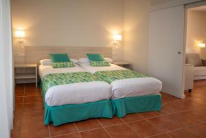 Schlafzimmer mit einem großen Bett mit grüner und weißer Bettwäsche in der Unterkunft Hotel Montepiedra 4''''sup in Playas de Orihuela