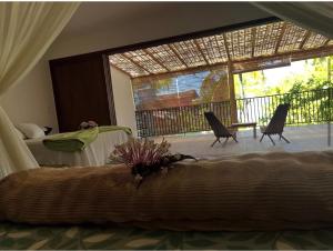 una camera con letto e un balcone con sedie di Casa Eugênio a Porto Seguro
