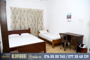 a room with two beds and a desk and a table at Aluvihare Residence in Matale +16 photos