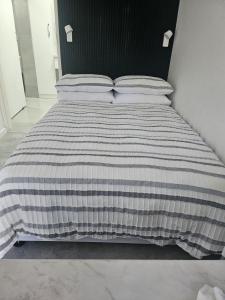 Una cama con un edredón de rayas blancas y negras en HomeAway Vredenburg, en Vredenburg