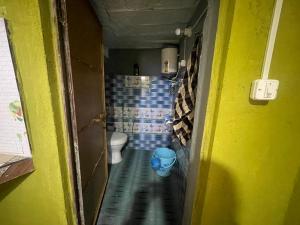 a small bathroom with a toilet and a blue bucket at Munsiyari Eco homestay in Munsyari