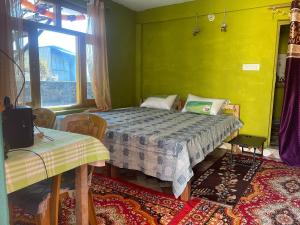a bedroom with a bed and a yellow wall at Munsiyari Eco homestay in Munsyari