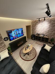 Una sala de estar con un sofá y un televisor de pantalla plana. en مدن هاوس ودخـول ذاتي, en Hail